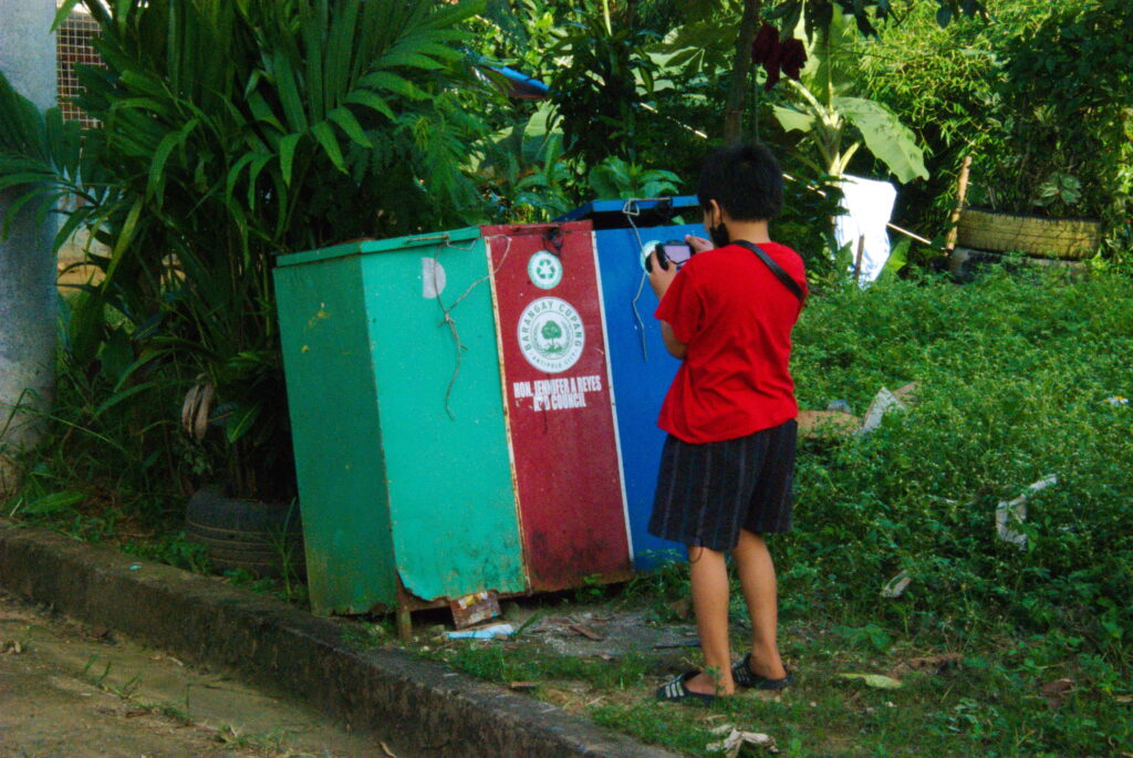Desmond taking pictures of trash cans
